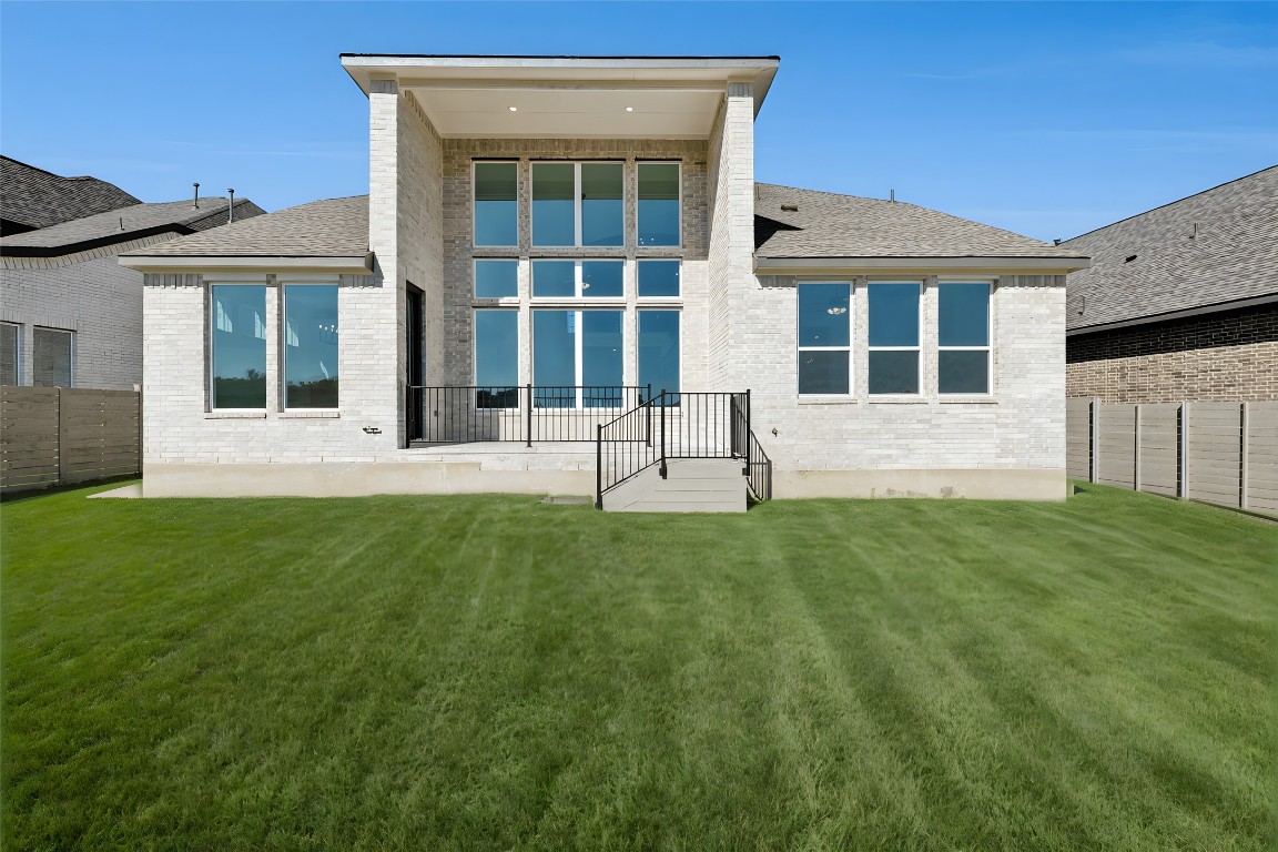 1533 Rodeo Ridge Drive Georgetown, TX 78628 - Photo 28 of 34 Back of house featuring brick siding, roof with shingles, and a fenced backyard