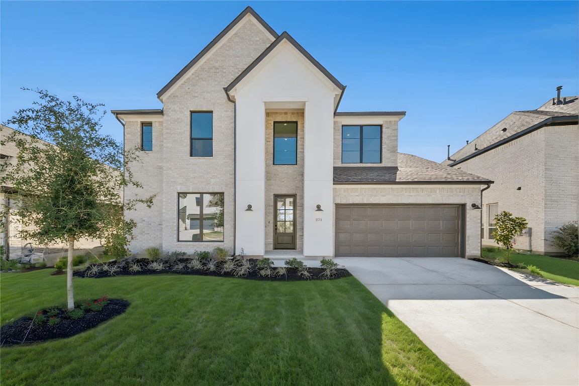 1533 Rodeo Ridge Drive Georgetown, TX 78628 - Photo 29 of 34 View of front of home featuring a front lawn, brick siding, a garage, driveway, and a shingled roof