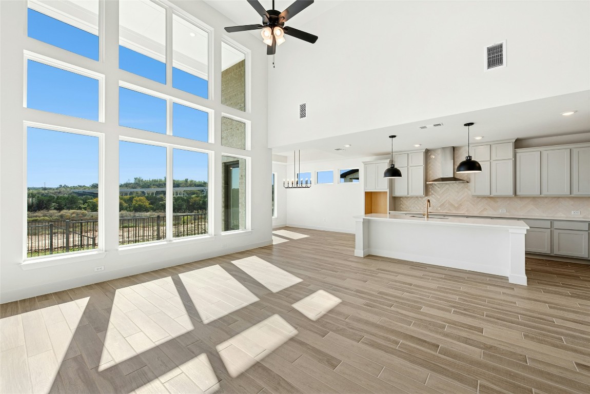 1533 Rodeo Ridge Drive Georgetown, TX 78628 - Photo 3 of 34 Unfurnished living room featuring a high ceiling, light wood-style flooring, and a ceiling fan
