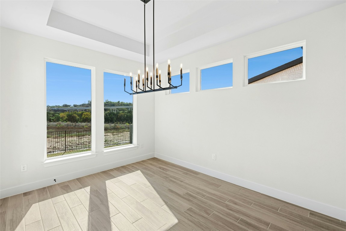 1533 Rodeo Ridge Drive Georgetown, TX 78628 - Photo 8 of 34 Empty room with healthy amount of natural light, light wood-style flooring, and a chandelier