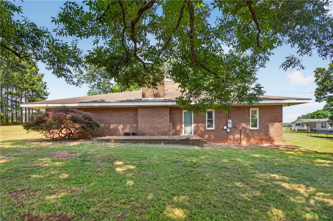 1412 Simpson Road Pendleton, SC 29670 - Photo 44 of 48 Mature trees frame this brick home, offering a tranquil retreat with a spacious yard.