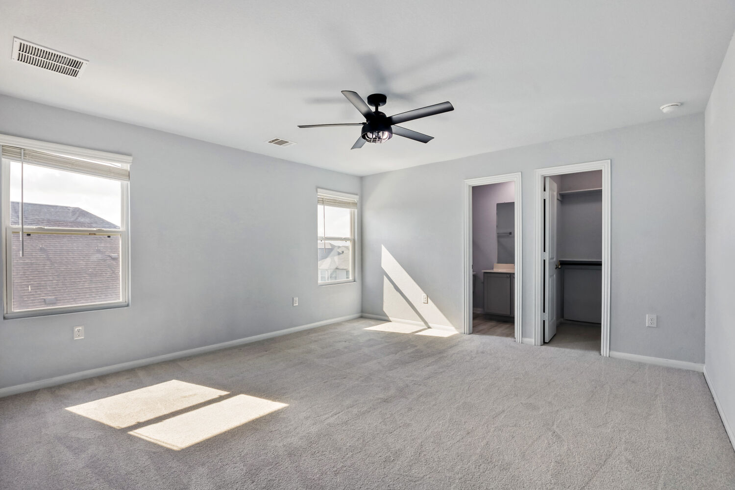 6601 Avila Way Pflugerville, TX 78660 - Photo 16 of 28 Unfurnished bedroom featuring a spacious closet, carpet flooring, a ceiling fan, and connected bathroom