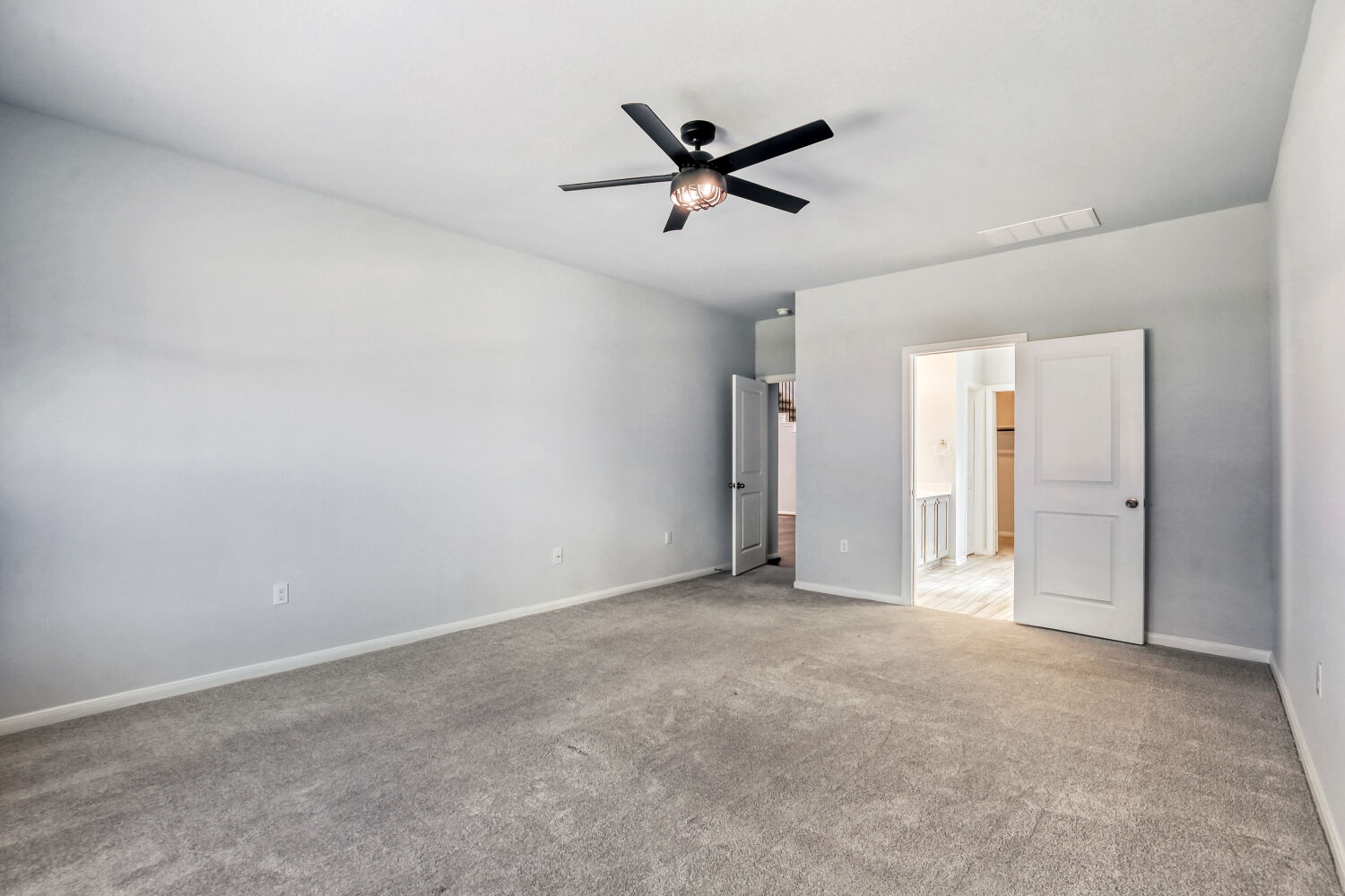 6601 Avila Way Pflugerville, TX 78660 - Photo 18 of 28 Unfurnished bedroom with light carpet, ceiling fan, and ensuite bath