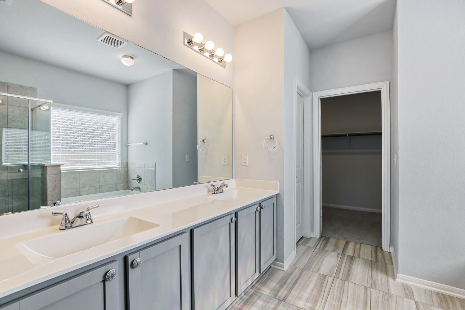 6601 Avila Way Pflugerville, TX 78660 - Photo 19 of 28 Bathroom featuring double vanity, a bath, a shower stall, and a walk in closet