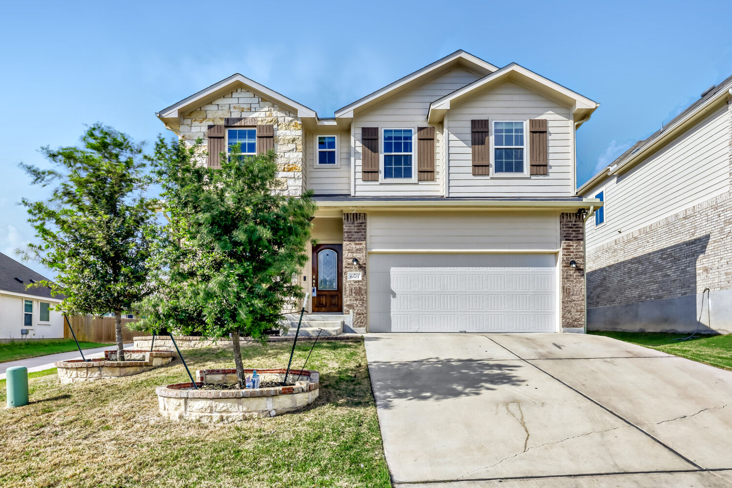 6601 Avila Way Pflugerville, TX 78660 - Photo 2 of 28 View of front of house featuring a garage, driveway, brick siding, and a front yard