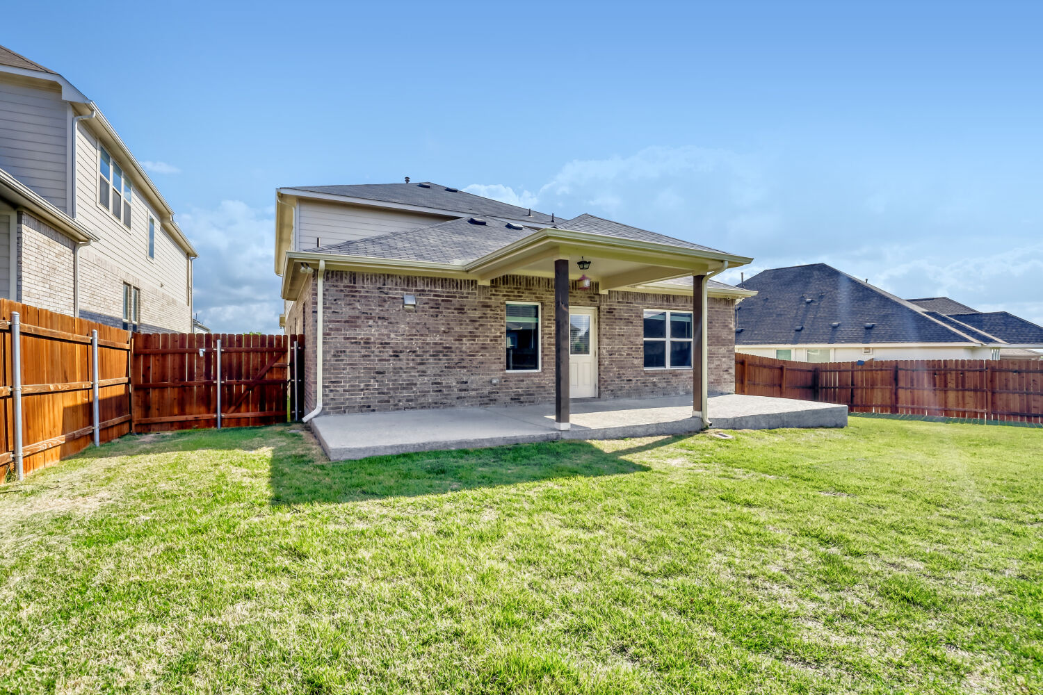 6601 Avila Way Pflugerville, TX 78660 - Photo 26 of 28 Back of property featuring brick siding, a patio area, roof with shingles, and a fenced backyard