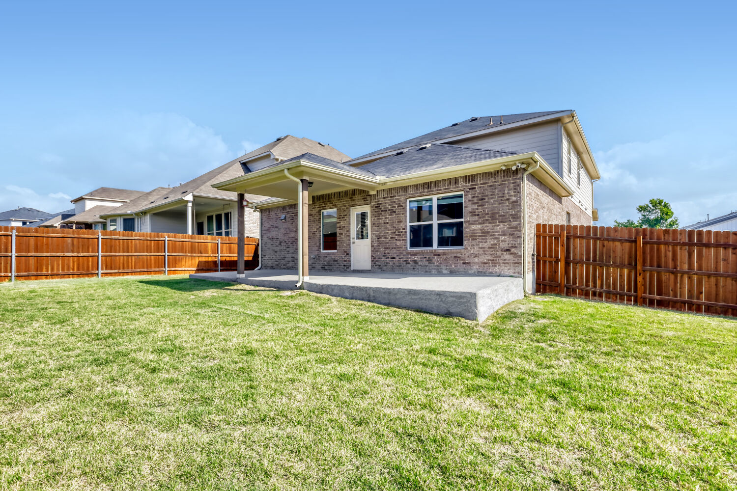 6601 Avila Way Pflugerville, TX 78660 - Photo 27 of 28 Back of house featuring brick siding, a patio, a fenced backyard, and roof with shingles