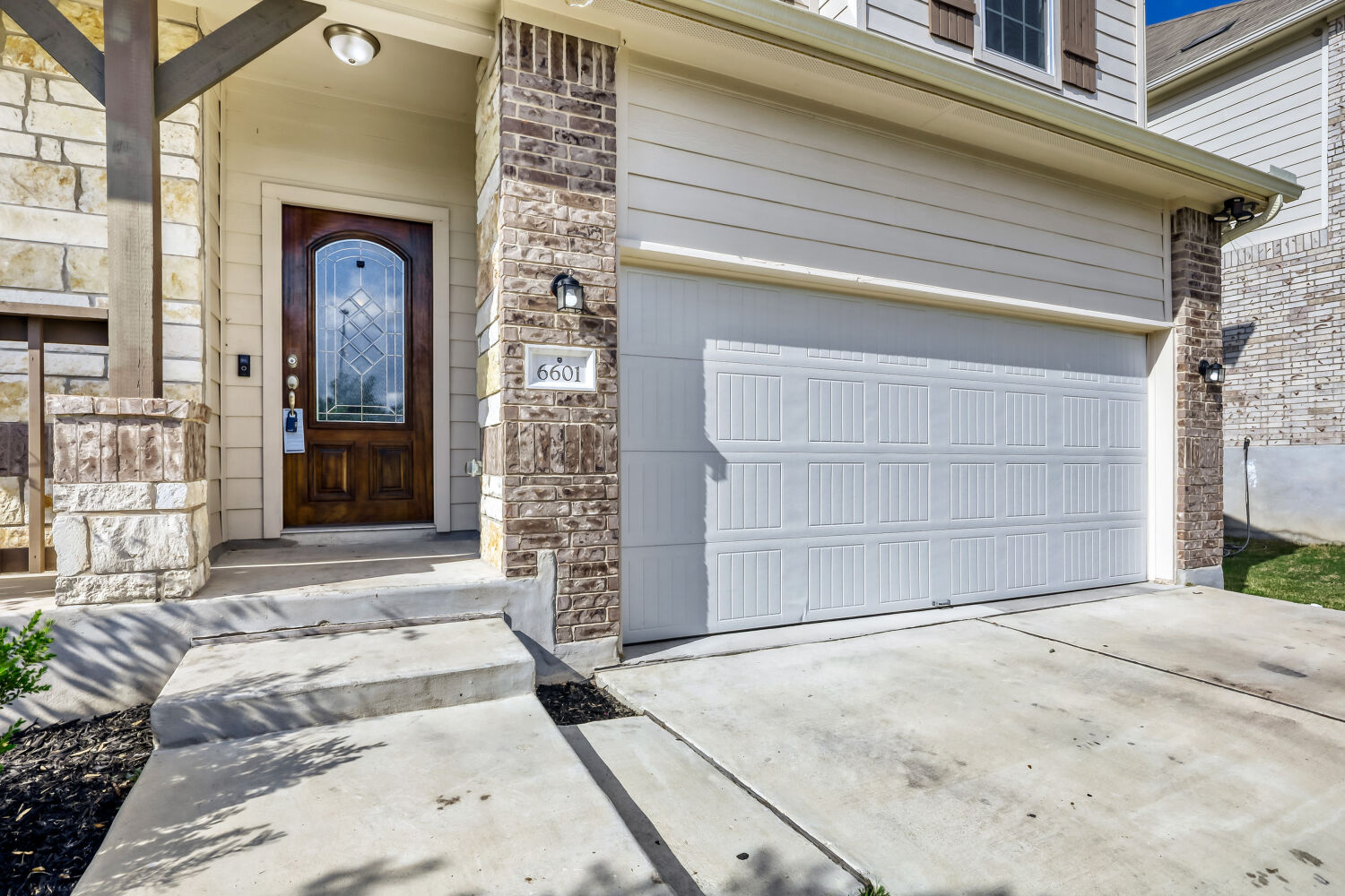 6601 Avila Way Pflugerville, TX 78660 - Photo 3 of 28 Entrance to property with concrete driveway, stone siding, and a garage