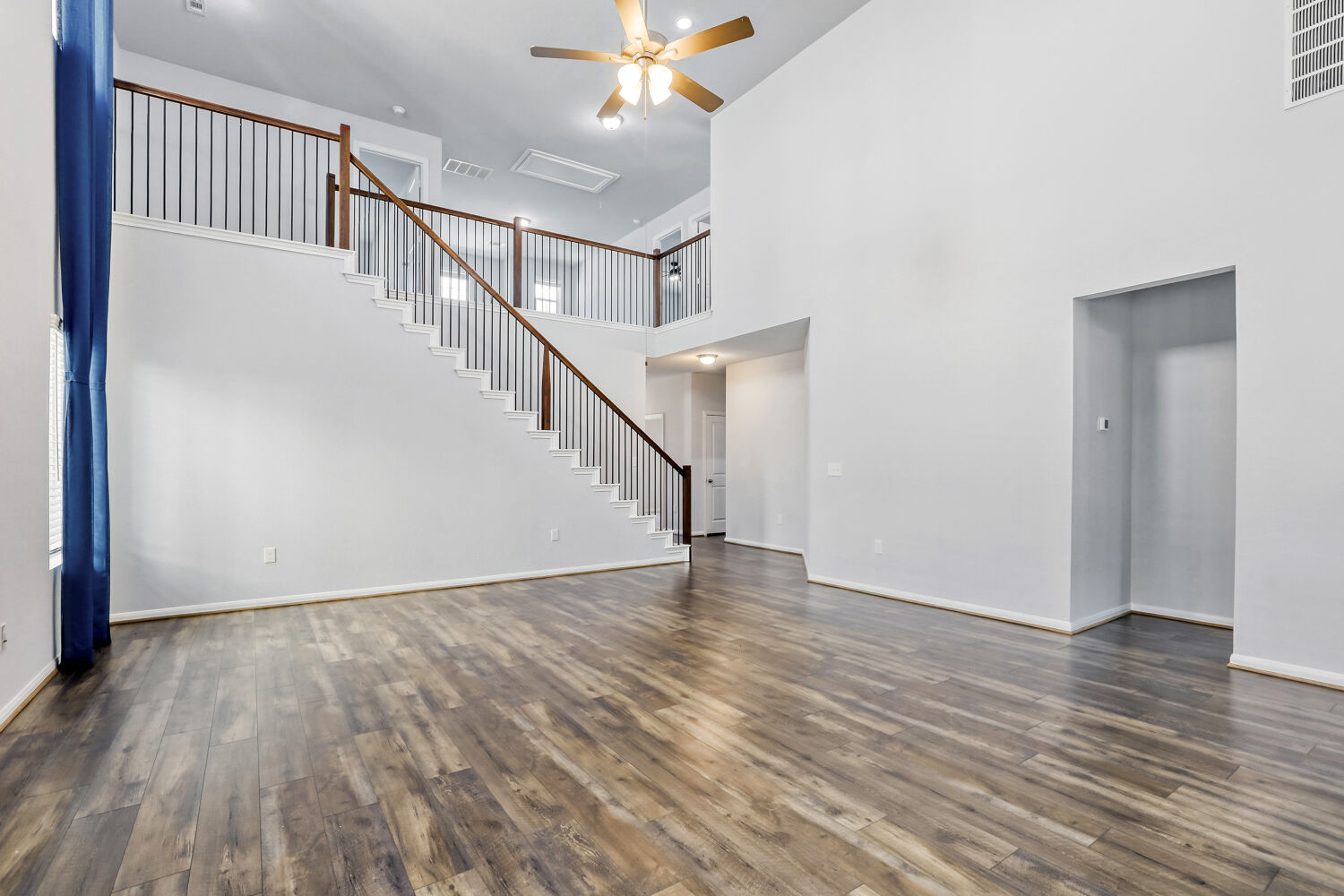 6601 Avila Way Pflugerville, TX 78660 - Photo 6 of 28 Unfurnished living room with a ceiling fan, dark wood finished floors, and a high ceiling