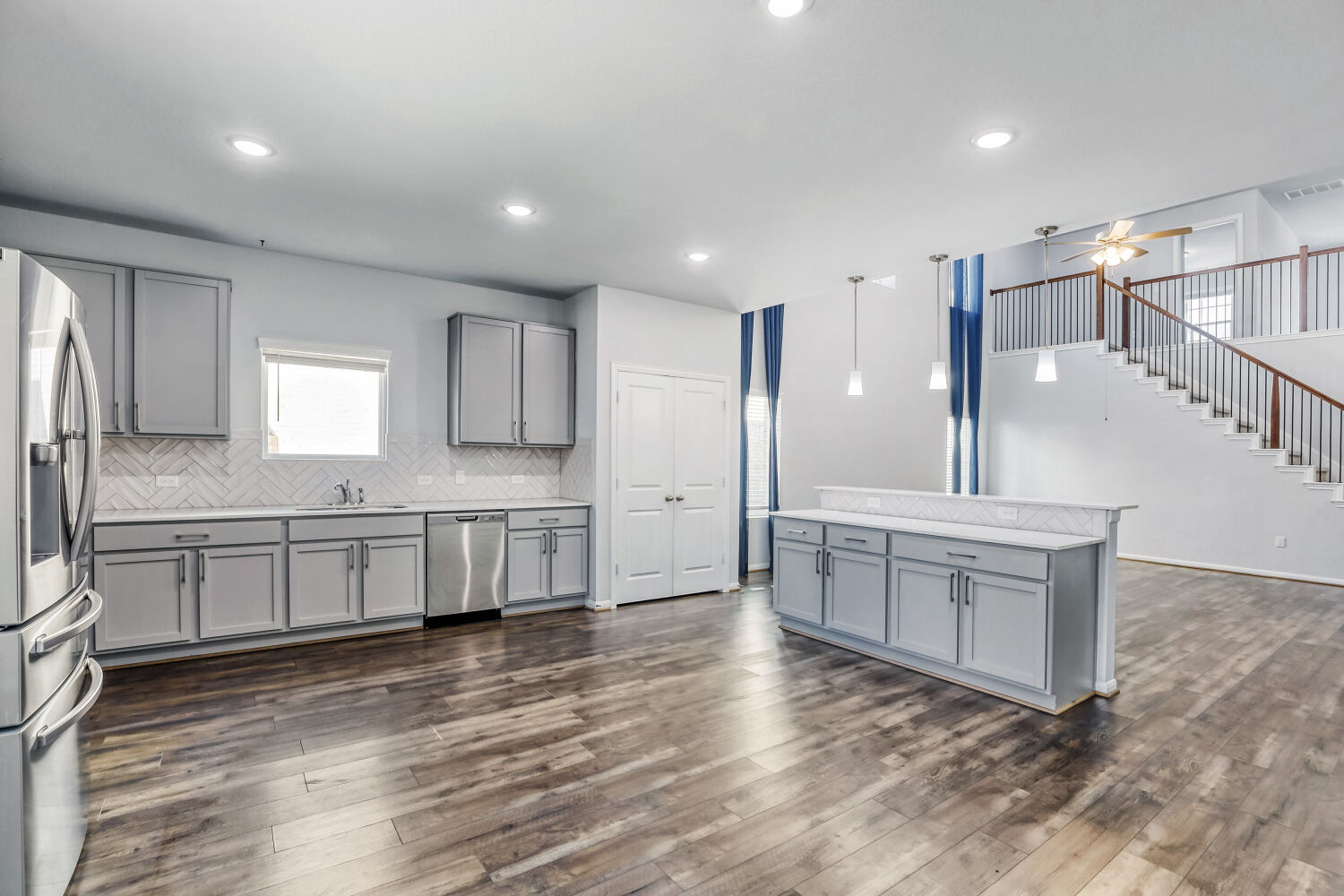6601 Avila Way Pflugerville, TX 78660 - Photo 8 of 28 Kitchen featuring gray cabinets, stainless steel appliances, light countertops, ceiling fan, and dark wood-type flooring