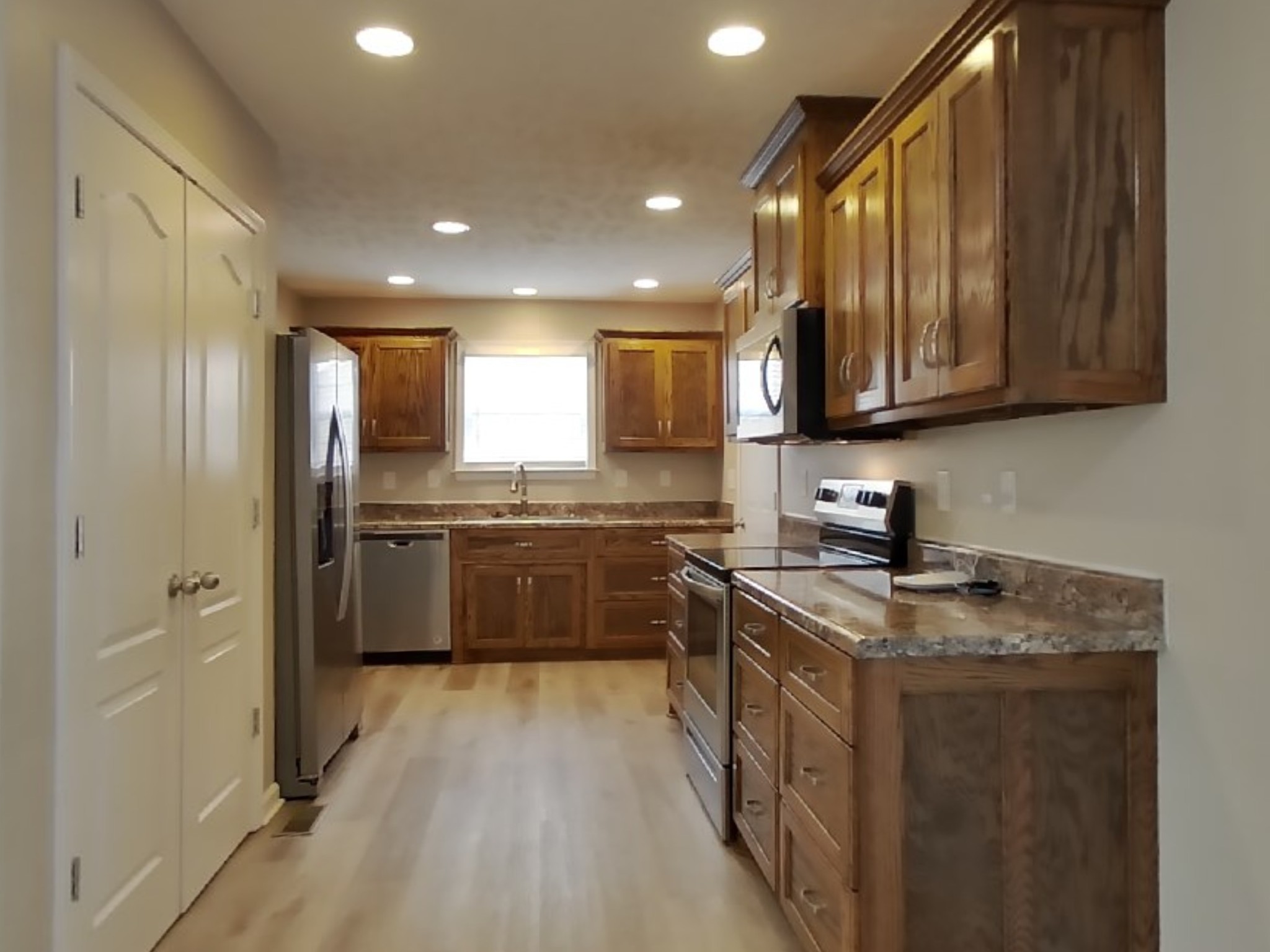 1908 Susan Road Columbia, TN 38401 - Photo 4 of 15 a kitchen with stainless steel appliances granite countertop a stove a sink dishwasher a refrigerator and a microwave oven with wooden floor