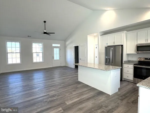 a large kitchen with stainless steel appliances a large counter top and a stove