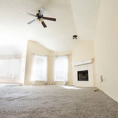 a view of a livingroom with a fireplace and a ceiling fan