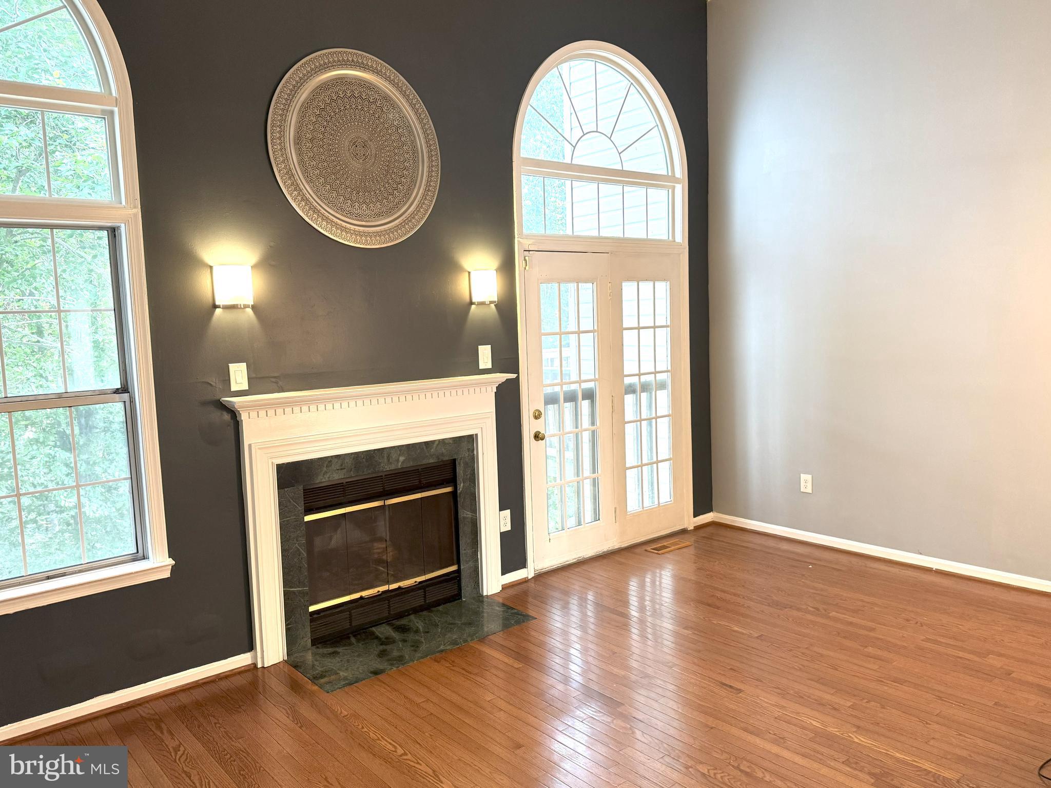 618 Evening Star Place Bowie, MD 20721 - Photo 6 of 59 an empty room with wooden floor fireplace and windows