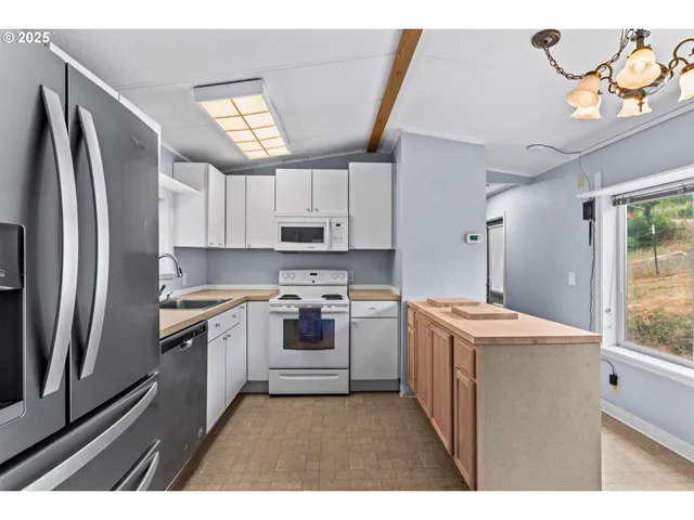 a kitchen with kitchen island granite countertop a sink stainless steel appliances and cabinets