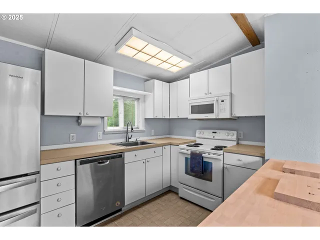a kitchen with cabinets appliances a sink and a window
