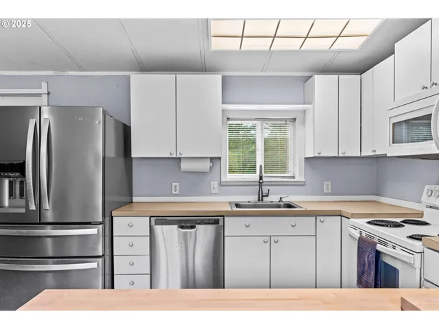 a kitchen with a sink a stove a refrigerator and cabinets