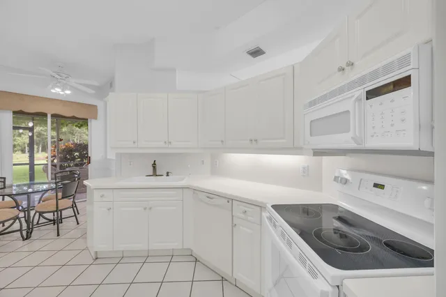 a kitchen with white cabinets appliances and sink