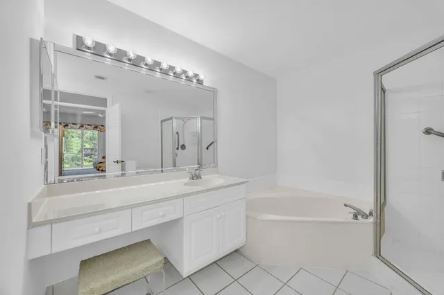 a bathroom with a tub sink and mirror