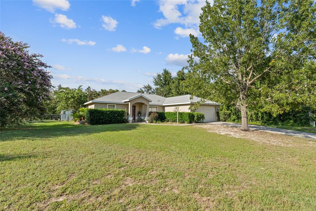 5065 Southwest 128th Street Ocala, FL 34473 - Photo 1 of 31 a front view of a house with a garden