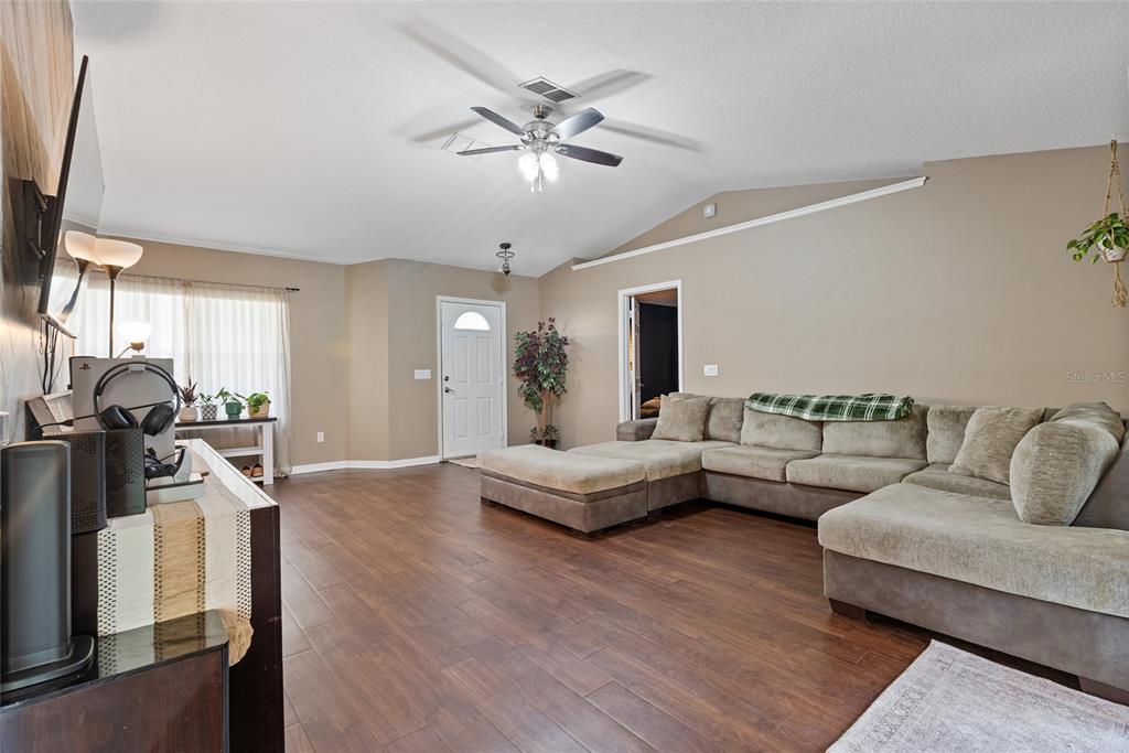 5065 Southwest 128th Street Ocala, FL 34473 - Photo 11 of 31 a living room with furniture and a chandelier