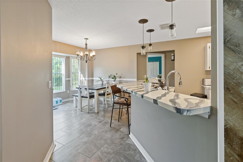 5065 Southwest 128th Street Ocala, FL 34473 - Photo 12 of 31 a living room with granite countertop furniture a fireplace and chandelier