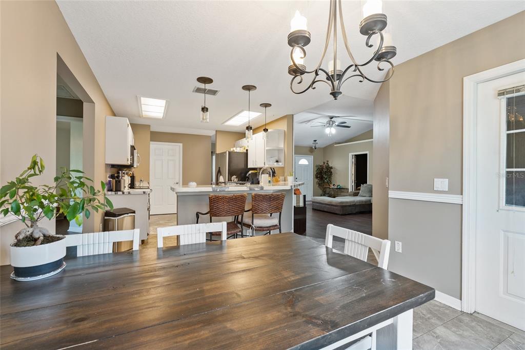 5065 Southwest 128th Street Ocala, FL 34473 - Photo 13 of 31 a living room with kitchen island furniture and a chandelier