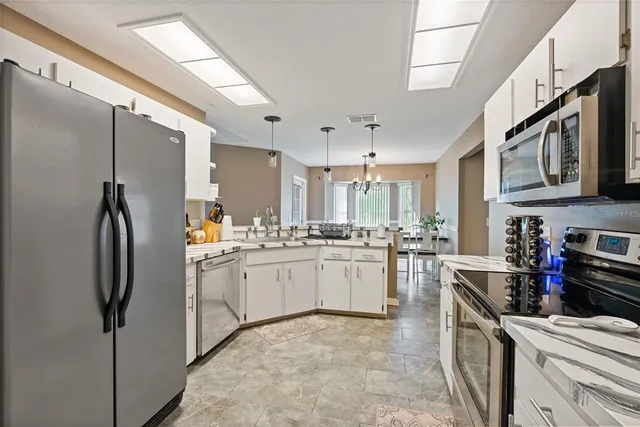 a kitchen with stainless steel appliances granite countertop a refrigerator a stove and a sink
