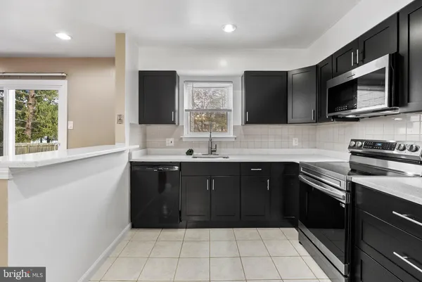 a kitchen with a sink stove and microwave