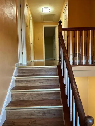 a view of staircase with railing and a chandelier
