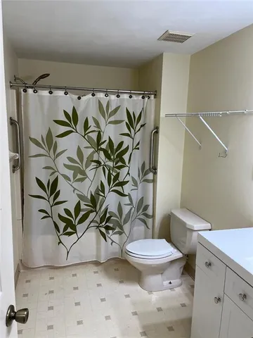 a bathroom with a granite countertop sink a toilet and a shower