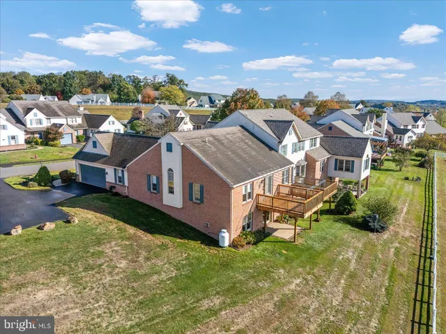 an aerial view of residential houses with outdoor space and trees