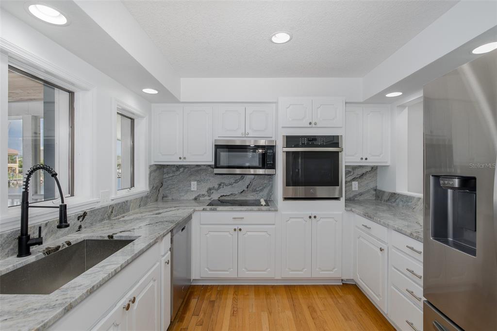 3150 Trident Terrace New Port Richey, FL 34652 - Photo 23 of 99 a kitchen with stainless steel appliances a sink a stove a microwave a sink a refrigerator and cabinets