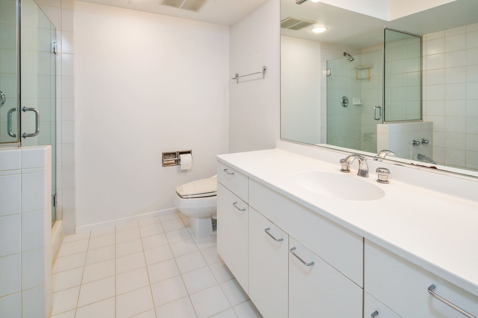 1618 Sheridan Road, Unit 5 Wilmette, IL 60091 - Photo 9 of 11 a spacious bathroom with a granite countertop sink a toilet and a mirror