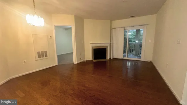 a view of an empty room with window and fire place