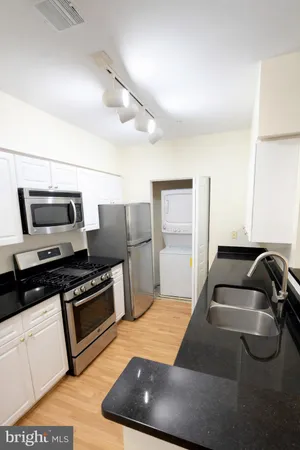 a kitchen with furniture and stainless steel appliances
