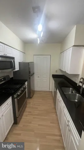 a kitchen with granite countertop a stove and a refrigerator