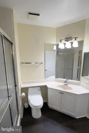 a bathroom with a sink a toilet a mirror and shower