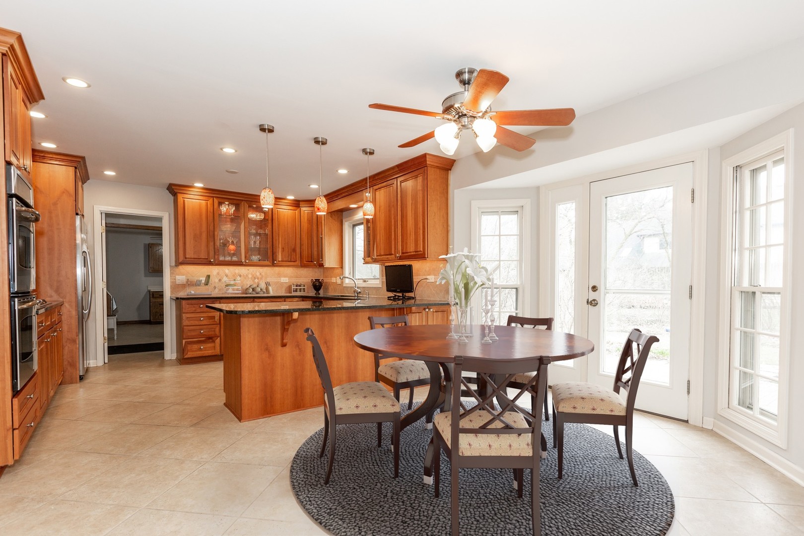 620 Buttonwood Circle Naperville, IL 60540 - Photo 5 of 29 a dining room with stainless steel appliances kitchen island granite countertop a table chairs and a refrigerator