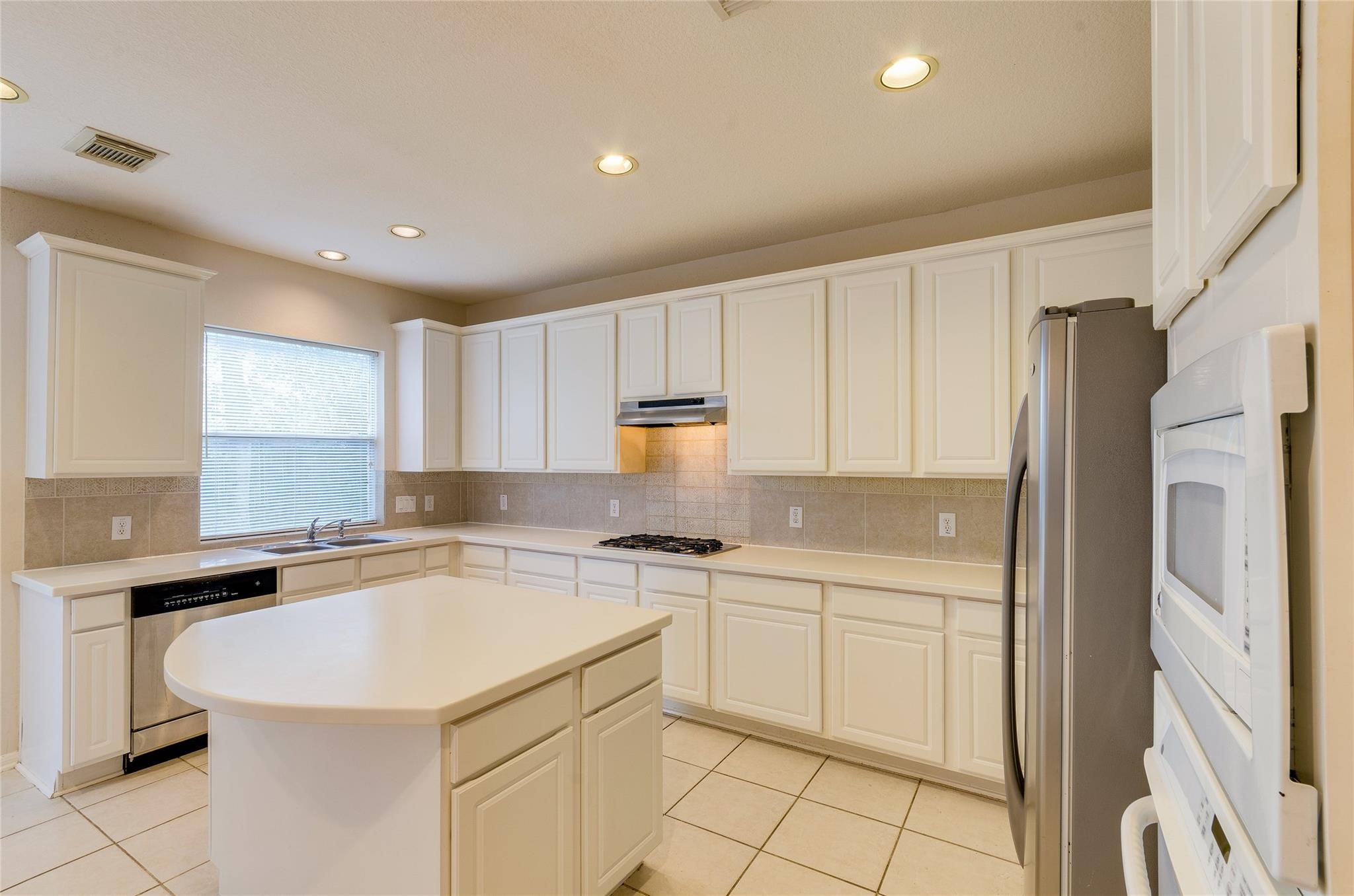 4019 Angel Spring Drive Sugar Land, TX 77479 - Photo 18 of 50 a kitchen with a sink a refrigerator and cabinets