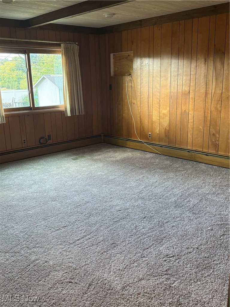 1284 Haverston Road Lyndhurst, OH 44124 - Photo 16 of 43 Empty room with carpet flooring, wooden walls, beamed ceiling, and baseboard heating