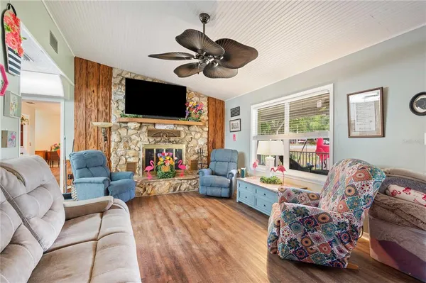 a kitchen with stainless steel appliances kitchen island granite countertop a refrigerator a sink dishwasher a stove and white cabinets with wooden floor