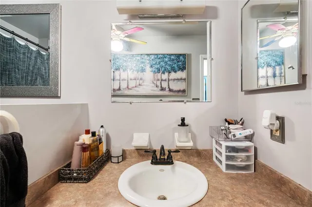 a bathroom with a granite countertop sink mirror vanity and toilet