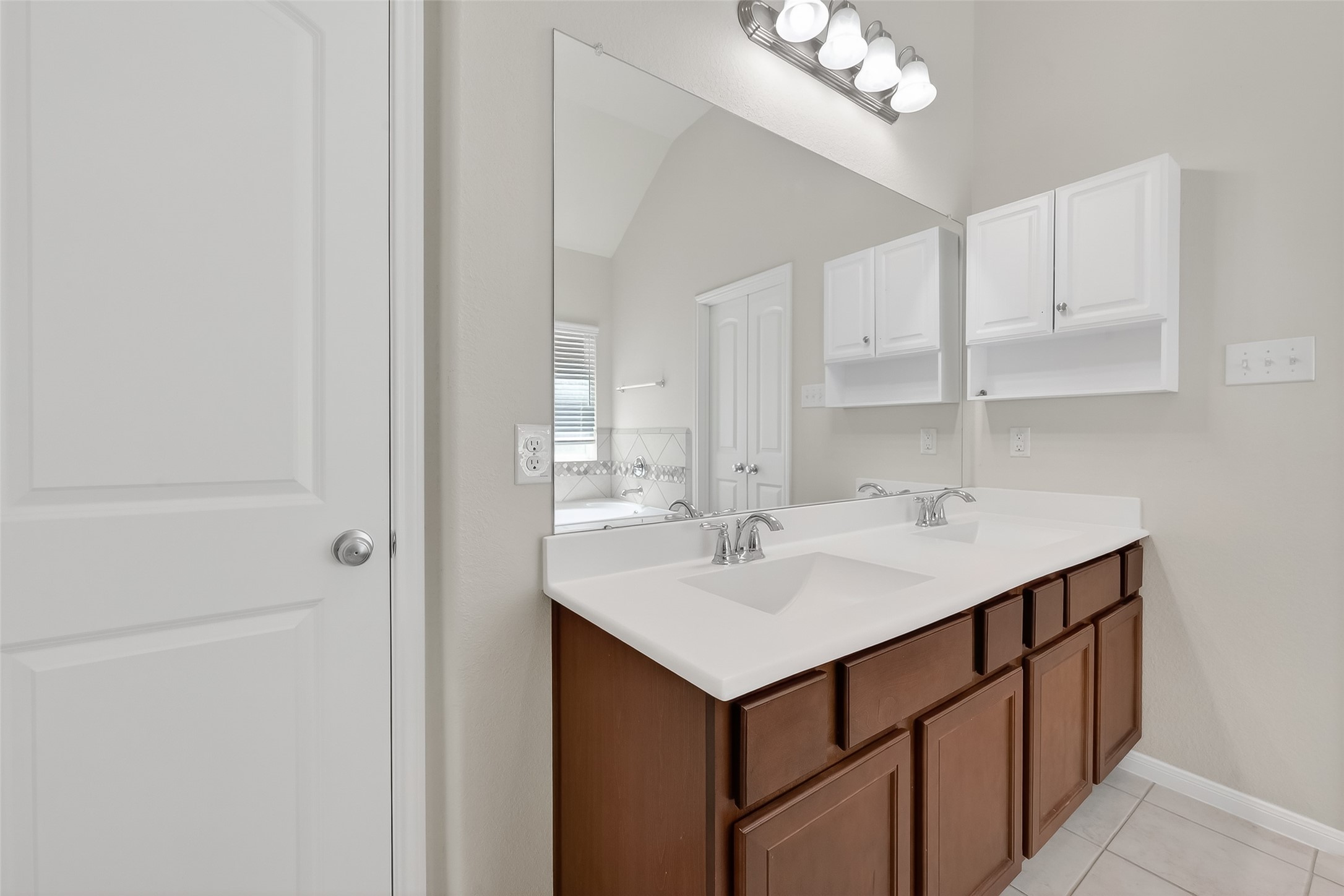 7631 Granite Terrace Lane Houston, TX 77083 - Photo 32 of 46 Bright bathroom with double sinks, modern fixtures, and ample storage. Features a large mirror and white cabinetry for a clean, spacious feel.