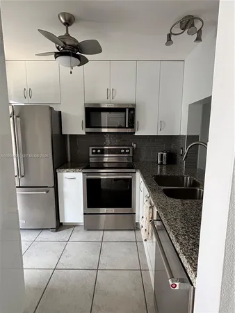 a kitchen with stainless steel appliances granite countertop a stove a refrigerator and a microwave