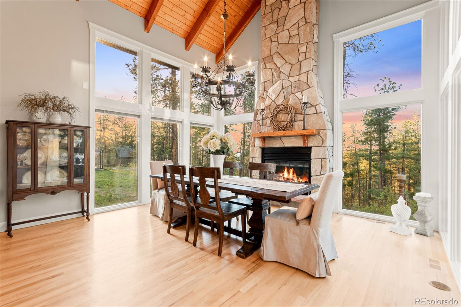 5090 South Perry Park Road Sedalia, CO 80135 - Photo 14 of 50 a dining room with furniture wooden floor and a fireplace