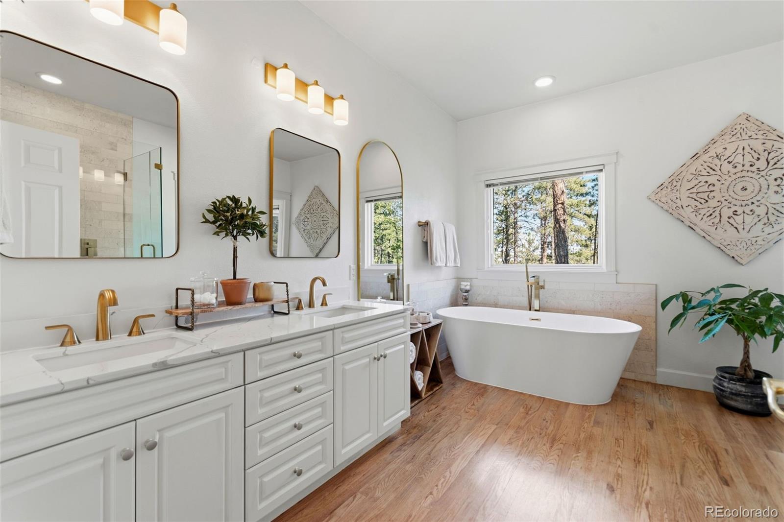 5090 South Perry Park Road Sedalia, CO 80135 - Photo 19 of 50 a spacious bathroom with double vanity sinks a large mirror and a bathtub