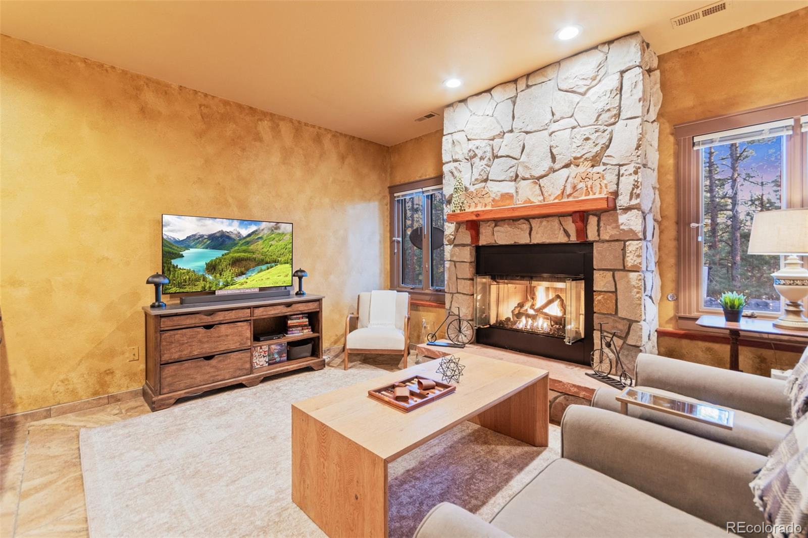 5090 South Perry Park Road Sedalia, CO 80135 - Photo 29 of 50 a living room with furniture a flat screen tv and a fireplace