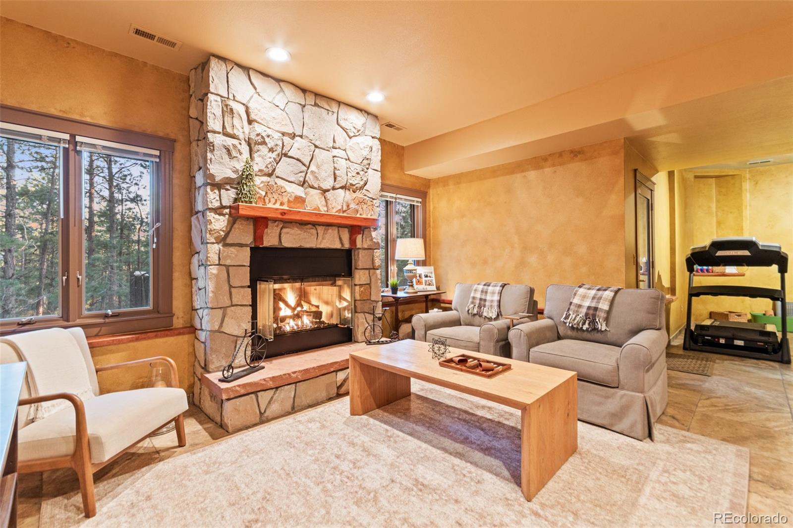 5090 South Perry Park Road Sedalia, CO 80135 - Photo 30 of 50 a living room with furniture a large window and a fireplace