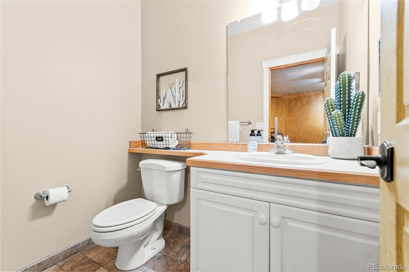 5090 South Perry Park Road Sedalia, CO 80135 - Photo 33 of 50 a bathroom with a sink a toilet and mirror